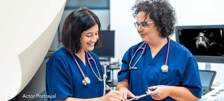 Two healthcare professionals reviewing information on a tablet, discussing the latest updates on DEFINITY®